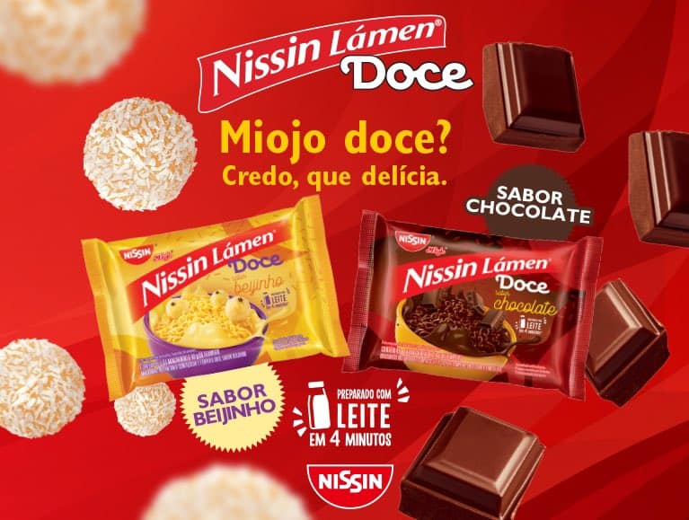 Imagem de divulgação dos miojos doces, com fundo vermelho, onde do lado esquerdo aparece o miojo de beijinho e do lado direito o miojo sabor chocolate. Há um título centralizado em amarelo com os dizeres: "Miojo doce? Credo, que delícia" e também o modo de preparo, que é com leite e demora 4 minutos.