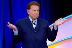 Imagem de Silvio Santos, suposto pai da idosa de 72 anos de idade, em um de seus programas, com as mãos espalmadas com expressão de não entender o que está acontecendo