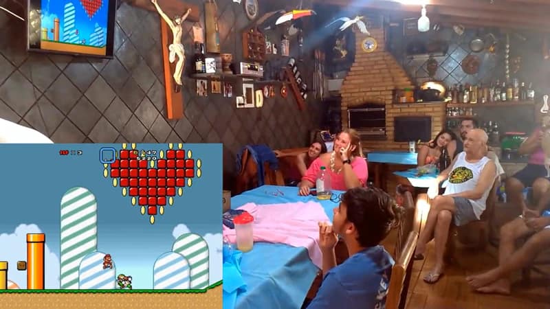 Família de Igor e Marinara, pais de Manuela cujo sexo foi revelado em chá de revelação criativo com jogo do Super Mário. Todos estão olhando para a televisão, onde o jogo está sendo transmitido.